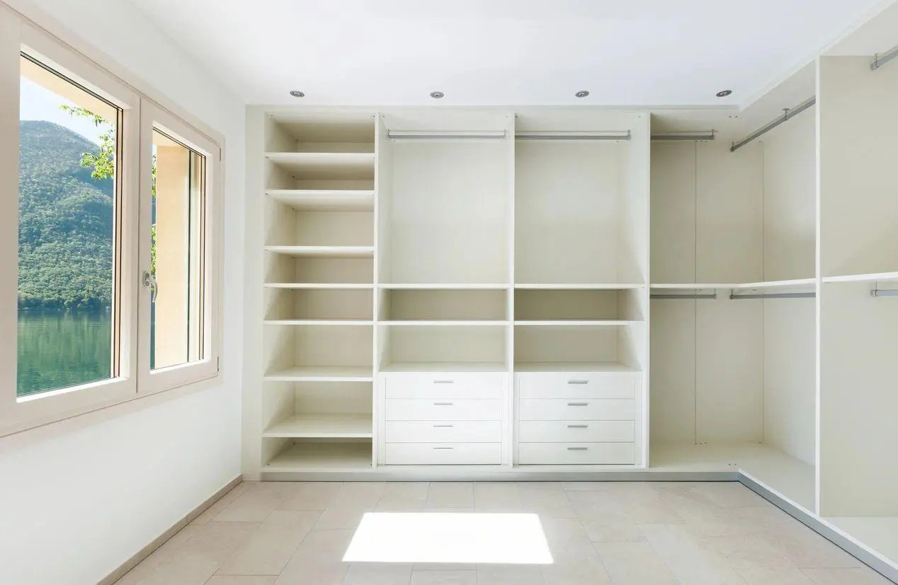 A white room with many shelves and drawers.