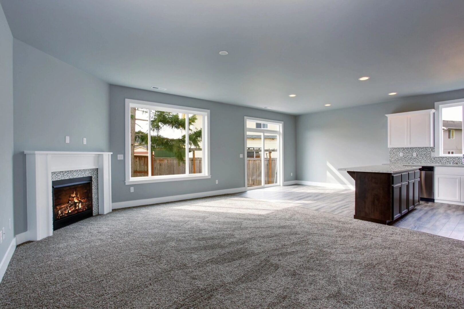 A living room with a fireplace and carpet.