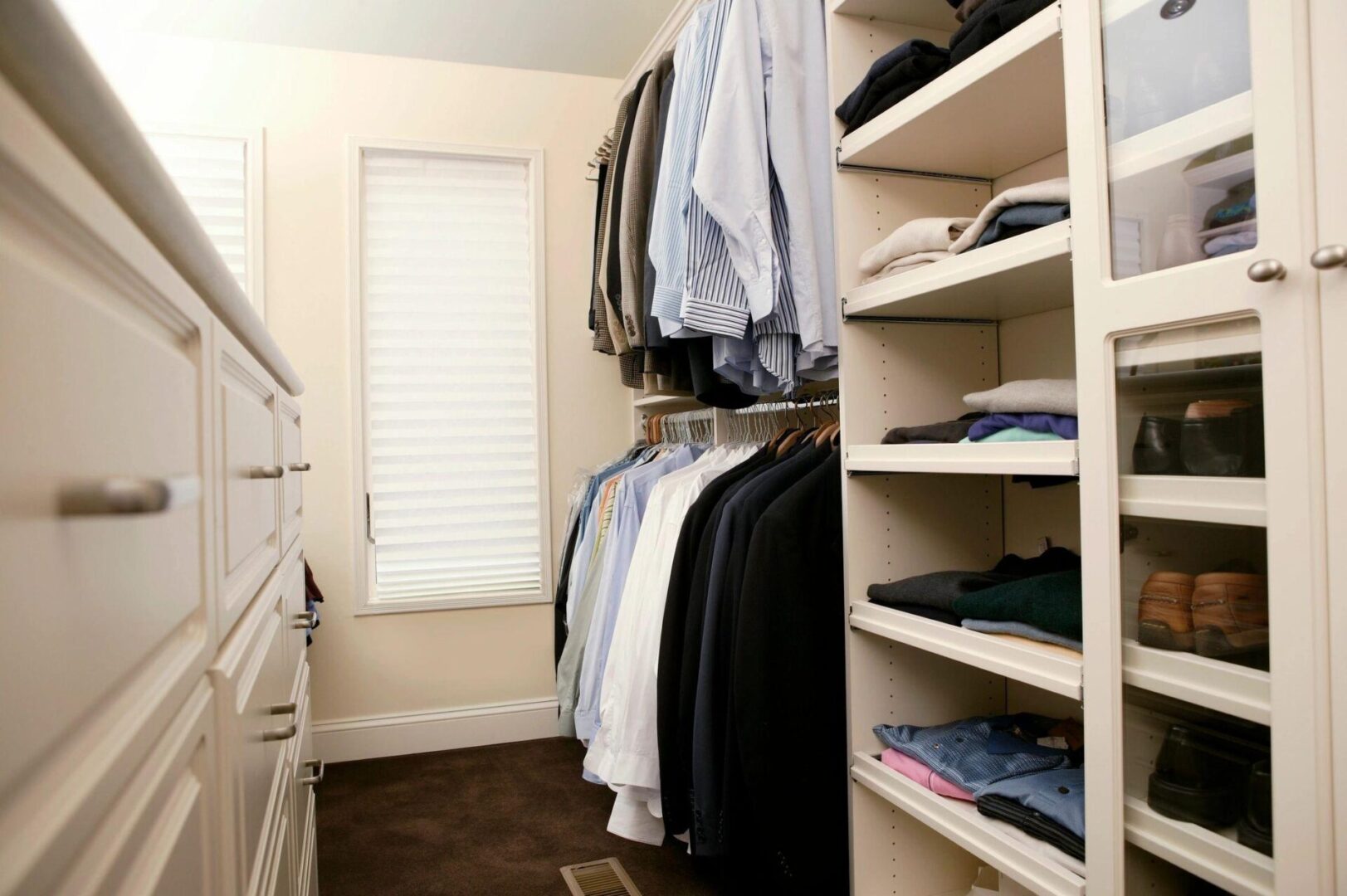 A closet with many clothes hanging on the racks.