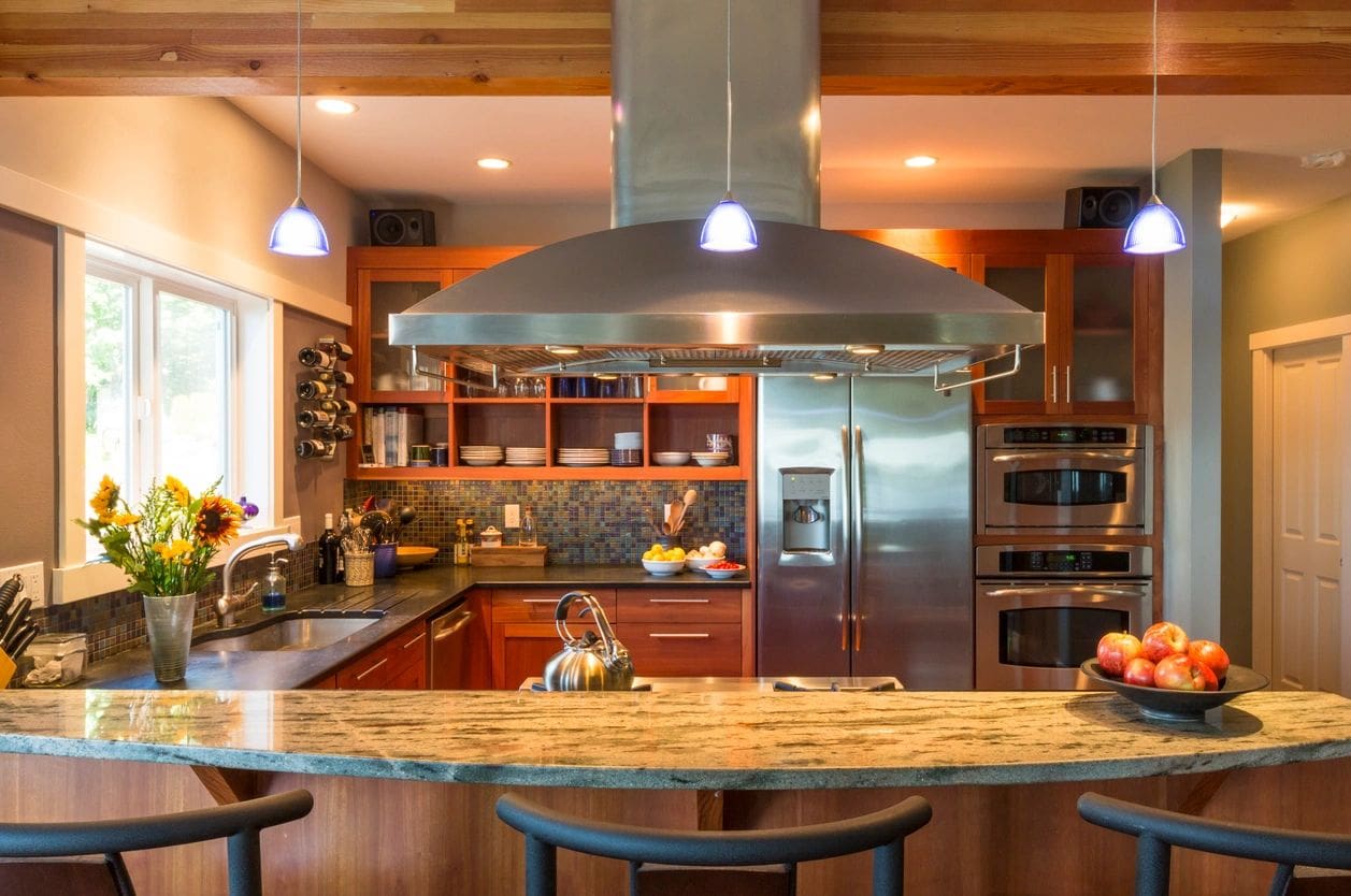 A kitchen with a large island and stainless steel appliances.