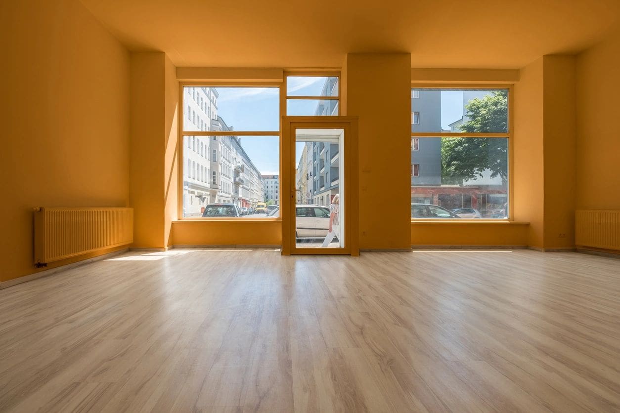 A room with wooden floors and large windows.