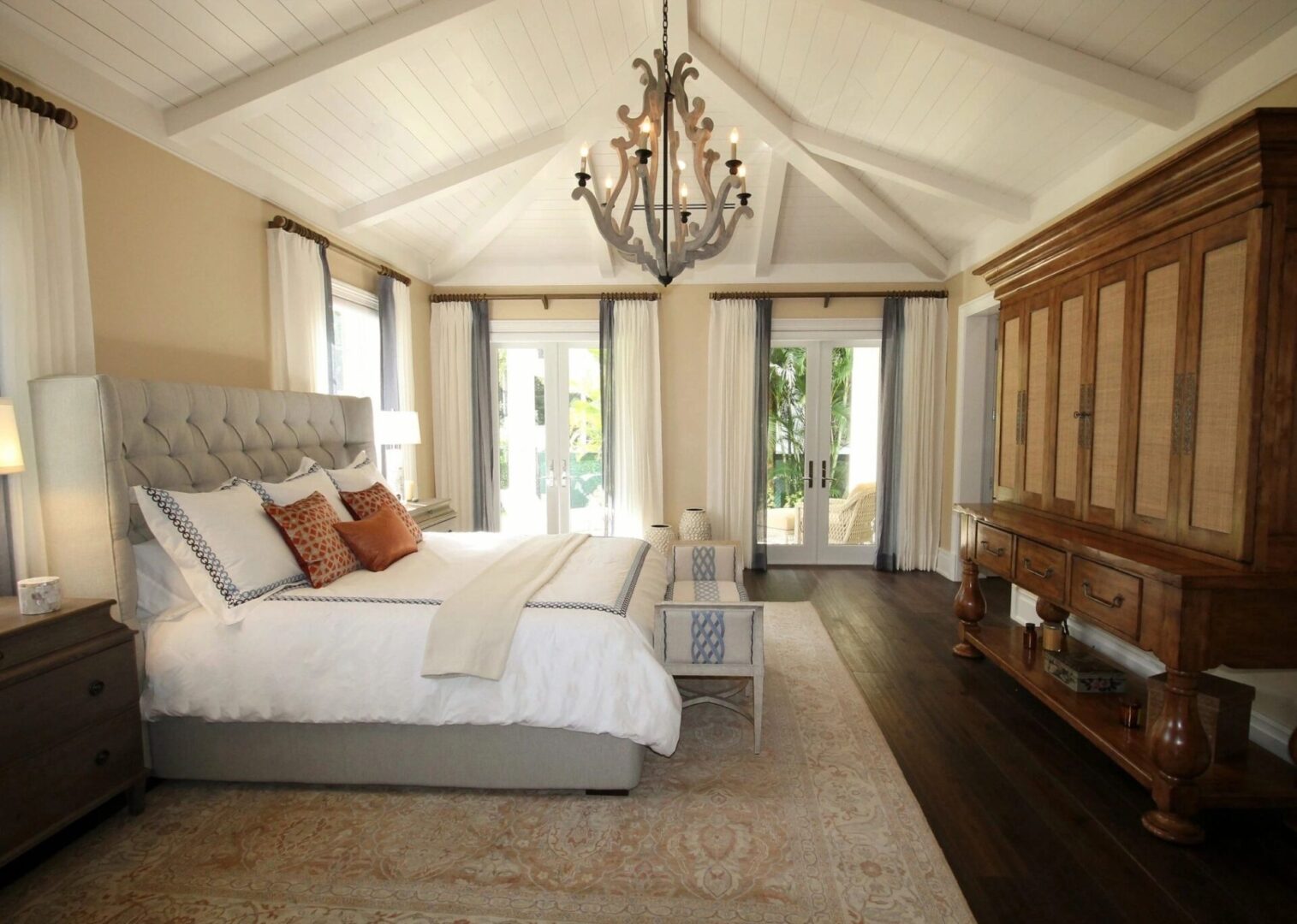 A bedroom with a large bed and chandelier.