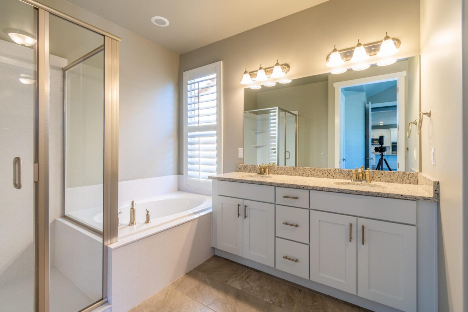 A bathroom with white cabinets and a tub.