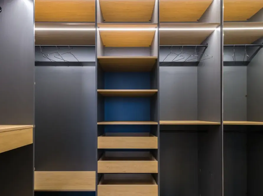 Spacious modern walk-in closet featuring wooden shelving and a sleek design, ideal for organization.
